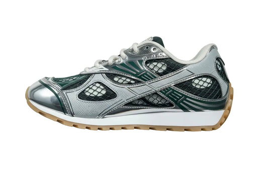 Gray and green sneaker with a white sole on a gray surface and light gray background